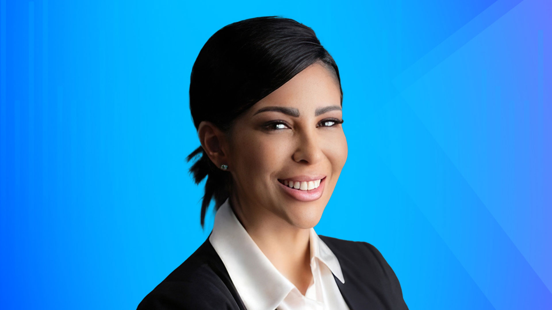 side on, smiling woman, black and white suit, blue background